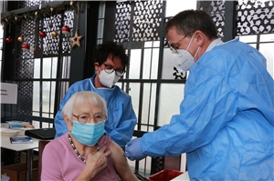 Das Foto zeigt eine alte Frau, die von einem Arzt geimpft werden.