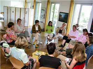 Eine Gruppe Frauen sitzt im Kreis und unterhält sich.