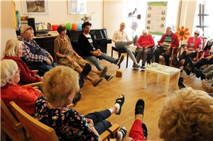 Das Foto zeigt eine Gruppe alter Menschen, die in einem Kreis sitzen.