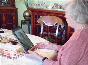 Das Foto zeigt eine Altenheim-Bewohnerin im Videogespräch auf einem Tablet.