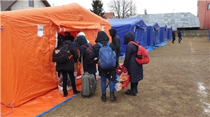 Das Foto zeigt eine Gruppe von Flüchtlingen vor Zelten.