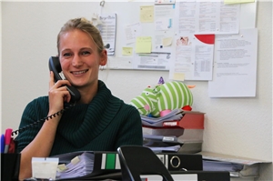 Das Foto zeigt Anna Menke in ihrem Büro telefonierend.