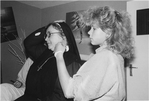 Das Foto zeigt eine Ordenschwester mit Jugendlichen in schwarz-weiß.