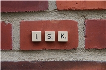 ISK Prävention Mit scrabbel-Buchstaben wurde das Wort "ISK" auf eine Backsteinmauer gelegt.
