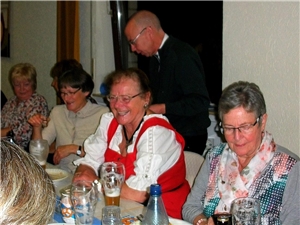 Mehrere Frauen sitzen amüsert an einem langen Tisch.