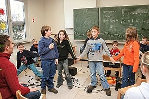 Auf dem Foto stehen Kinder in einem Klassenzimmer in einem Kreis