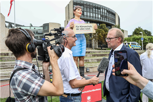Markus Lahrmann hält mit einem Handmikrofon ein Interview mit dem SPD-Fraktionsvorsitzenden Jochen Ott vor dem Düsseldorfer Landtag. Das Interview wird von einem Mann gefilmt.