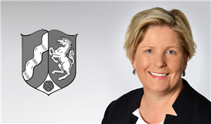 Porträt: Claudia Middendorf auf der rechten Seite des Bildes, auf der linken Seite ist das Wappen des Landes Nordrhein-Westfalen in schwarz-weiß zu sehen.