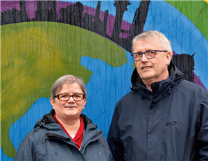 Schwester Martina Paul und Klaus-Peter Bongardt vor einer mit Graffiti besprühten Wand