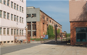 Frontaufnahme einer Zementfabrik an der Donau mit dem Eingangstor und drei Fabrikhallen