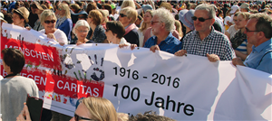 Ein Gruppe von Frauen und Männern halten während einer Papstaudienz auf dem Petersplatz im Zuge einer Pilgerfahrt ein Banner zum 100-jährigen Bestehen des DiCV Münster hoch