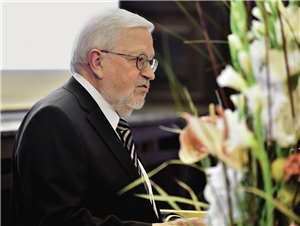 Verbandsvorsitzender Ludger Twachtmann steht vor einem Pult und hält beim Festakt zum 100-jährigen Bestehen der Caritas Recklinghausen eine Rede 
