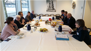 Vier Vertreter der Fraktion 'Bündnis 90/Die Grünen' im Landtag NRW und fünf Vertreter der Caritas in NRW sitzen in einem Besprechungsraum an einem gedeckten Frühstückstisch.
