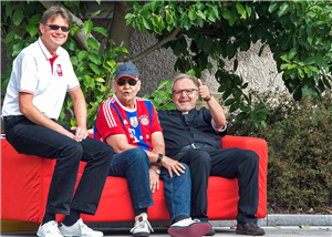 Hubertus Böttcher, Christian Stockmann und ein Bürger sitzen an einer Straße auf einem roten Sofa
