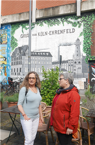 Michaela Pfaff und Anne Kuhlmann stehen vor einer besprayten Mauer in Köln-Ehrenfeld