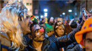 Zwei Männer, die sich auf einer abendlichen Karnevalsveranstaltung in Köln aufhalten und ein Selfie machen. Um sie herum befinden sich viele verkleidete Menschen.