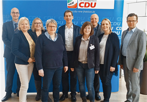 Gruppenfoto mit Vertreter/innen der CDU-Landtagsfraktion NRW und Caritas in NRW vor einem Faltdisplay der CDU NRW
