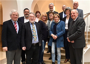 Ein Gruppenfoto mit Vertreter/innen der SPD-Fraktion im LWL und der Caritas in NRW, die vor einem Treppenaufgang stehen