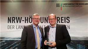Christian Heine-Göttelmann (Vorsitzender der LAG Freie Wohlfahrtspflege NRW) und Matthias Scherff (Dortmunder Lokalradio 91,2) stehen zusammen. Matthias Scherff hält seine Preis in der Hand. 