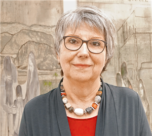 Porträt: Barbara Geis, vor zwei Bannern aus einer Kunstinstallation zum Heiligen Jahr 2015/2016 im Aachener Dom