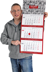 Porträt: Uwe Elsner, der einen selbst produzierten Dreimonatskalender hoch hält 