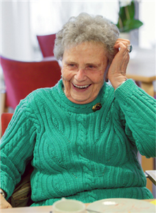 Eine Seniorin lachend in die Haare greift