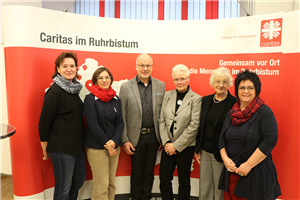 Die Referent/innen der CiNW-Fachtagung zum Pflegeberufegesetz am 03.12.2019 in Essen, die vor einem Faltdisplay der Caritas im Ruhrbistum stehen