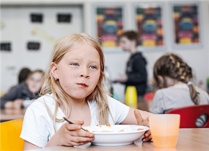 Ein Mädchen beim Essen in den Räumen einer Offen Ganztagsschule