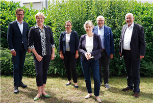 Ein Gruppenfoto mit Carsten Linnemann und einigen Vertreterinnen und Vertretern der Caritas aus Freiburg und Paderborn auf einer Wiese