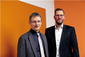 Porträt von Dr. Frank Johannes Hensel (Direktor des DiCV Köln) und Christian Woltering (Landesgeschäftsführer des Paritätischen NRW) vor einer weiß-orangen Wand