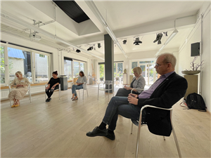 Teilnehmende einer Gesprächsrunde beim Besuch von NRW-Europastaatssekretär Dr. Marks Speich im Zentrum Kukuna in Wuppertal, die zusammen in einem Stuhlkreis sitzen