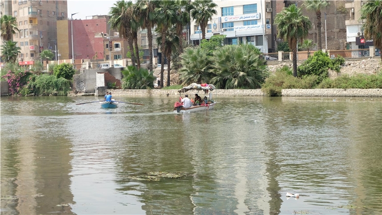 Eine kleine Fähre bringt Menschen von einer Insel im Nil zum Ufer. Dort stehen die Hochhäuser von Kairo. - Kairo. 