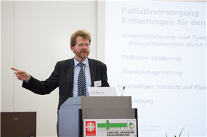 Prof. Dr. Lukas Radbruch steht vor eine Pult und hält eine Rede