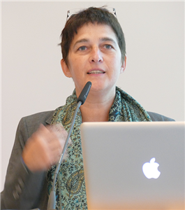 Ministerin Barbara Steffens steht vor einem Rednerpult mit Laptop und hält eine Rede