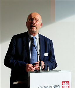 Der Paderborner Diözesan-Caritasdirektor Josef Lüttig steht bei der CiNW-Fachtagung 'Sozialer Arbeitsmarkt in Nordrhein-Westfalen' am 10.10.2019 an einem Pult und hält seine Begrüßungsrede