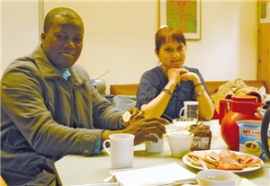 Ein Teilnehmer und eine Teilnehmerin des Frühstückstreffs des SkF und der Diakonie Wuppertal sitzen an einem Tisch und Frühstücken