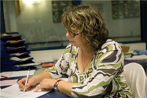 Eine weibliche Pflegekraft führt in einem Büro eine Pflegedokumentation