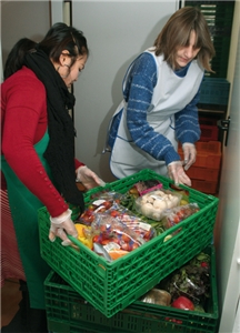 Zwei Helferinnen des Warenkorbs der Caritas Ahlen stapeln Kisten mit Lebensmitteln