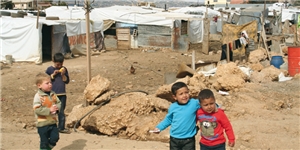 Vier syrische Kinder stehen vor dem Flüchtlingslager Delhamiye