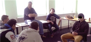 Der Anti-Aggressivitäts-Trainer Hanjost Völker sitzt mit fünf Teilnehmern eines Kurses kreisförmig zusammen