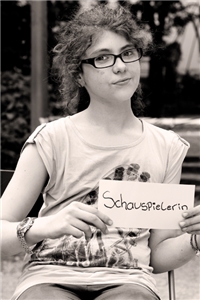Maria (12) am Rathenauplatz in Köln. Sie hält ein Schild mit der Aufschrift 