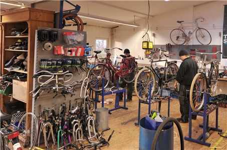Zwei Männer arbeiten in der Fahrradwerkstatt im Schloss Bellinghoven der Caritas Oberhausen.