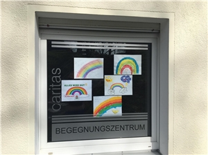 Bilder mit gemalten Regenbogen in einem Fenster