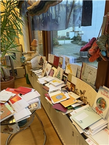Weihnachtsgrußkarten türmen sich auf Tisch und Fensterbank der Caritas in Langen