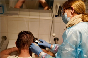 Krankenschwester schneidet einem Patienten die Haare