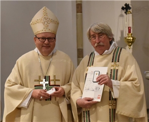 Als Dank für sein Engagement überreicht Bischof Dr. Franz-Josef Bode (lks) das Ehrenkreuz der Caritas in Gold an Diakon Dr. Gerrit Schulte.