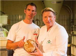 Rainer Welp und Ludger Abeln halten ein fertiges Brot in den Händen