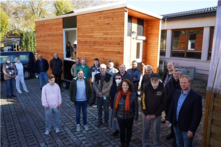 Präsentieren das fertige Tiny House: Azubis des Berufsförderzentrums mit ihren Ausbildungsleitern und Vertretern der Fachverbände des Caritasverbandes im Erzbistum Paderborn. 