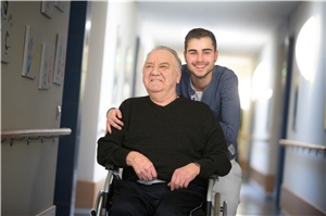 Älterer Rollstuhlfahrer mit Altenpfleger