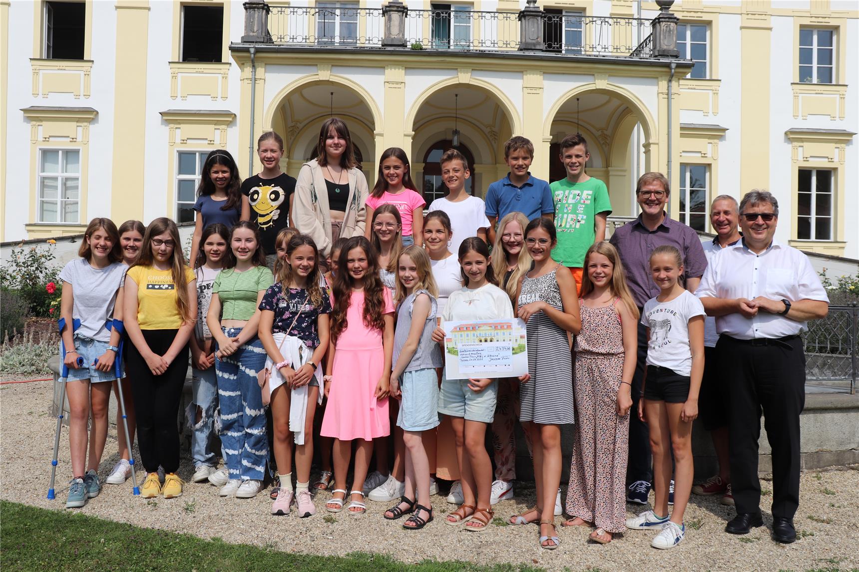 Schüler übergeben einen Spendenscheck für Caritas-Ukrainehilfe